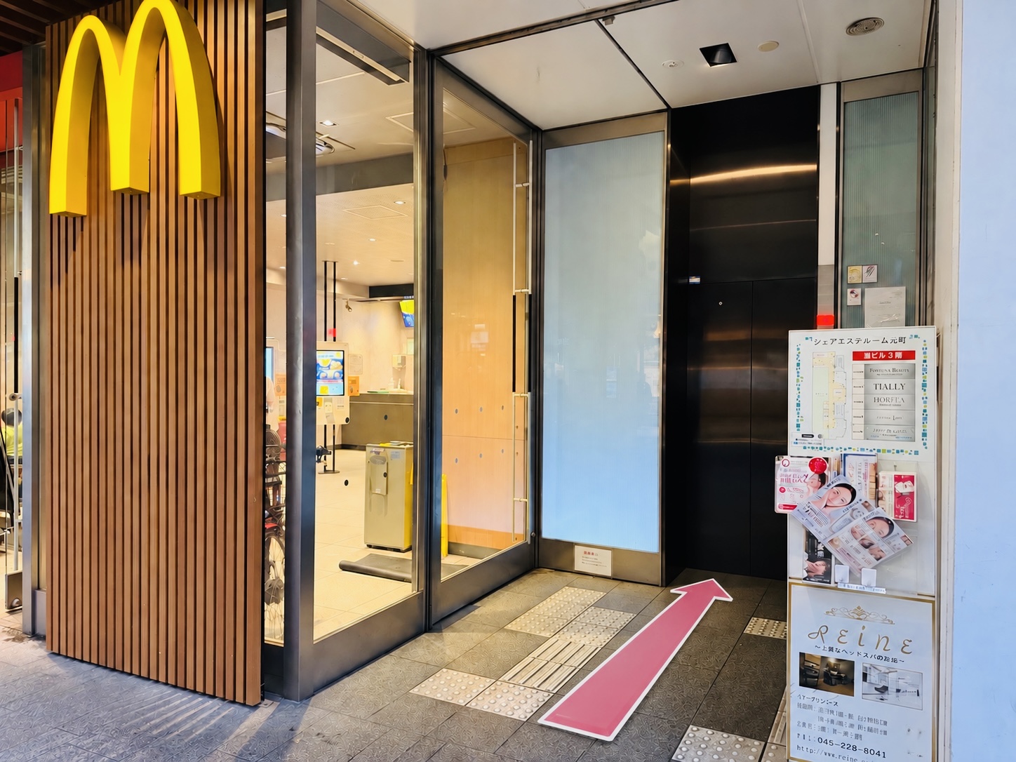 マクドナルドの店舗入口の隣にある黒い扉のエレベーター